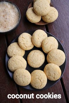 coconut cookies on a black plate next to a cup of coffee