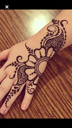 a person's hand with henna tattoos on it