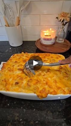 a person is spreading cheese on top of a casserole