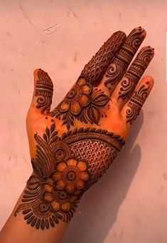 a woman's hand with hennap on it and an orange flower design