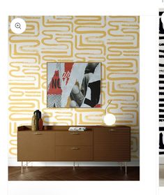 an image of a room with yellow and white wallpaper on the walls, and a sideboard in front of it