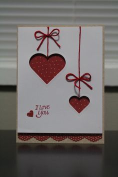 a card with two hearts hanging from strings