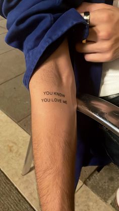 a man with a tattoo on his leg that says you know you love me,