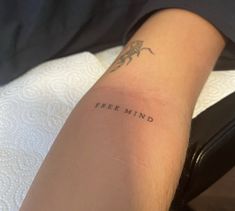 a woman's arm with the word free mind tattooed on it