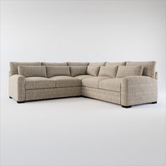 a beige sectional couch with pillows on the top and bottom corner, in front of a white background