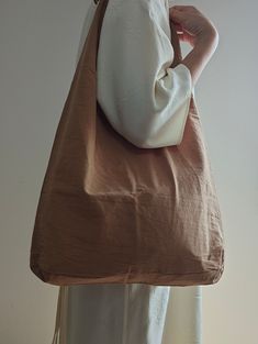 a woman holding a brown and white purse