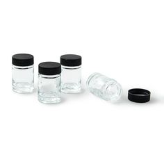 four glass jars with black lids are lined up