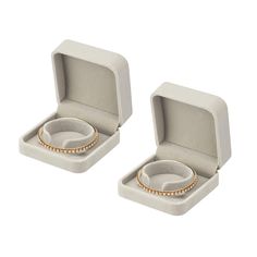 two white boxes with gold rings inside one and another in the other, on a white background