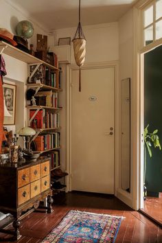 a room with bookshelves and a rug on the floor in front of a door