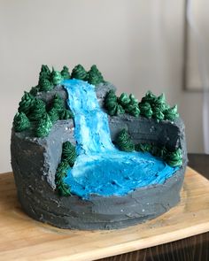 there is a cake that looks like it has a waterfall and trees on the side