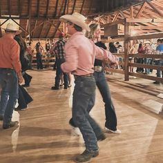 a group of men in cowboy hats are dancing on the dance floor at a rodeo