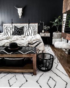 a bedroom with black walls and white rugs on the floor, including a bed