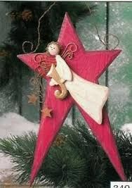 a wooden star ornament with an angel sitting on it's side in the snow