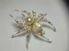 a close up of a brooch with pearls and beads on it's side