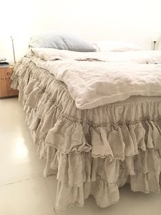 a bed with ruffled bedspread and pillows