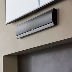 an air conditioner mounted to the side of a wall next to a mirror and window