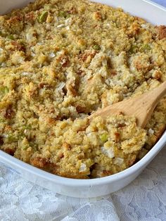 a casserole dish with stuffing and a wooden spoon