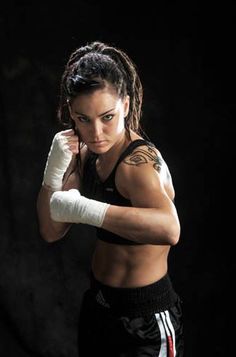 a woman wearing boxing gloves posing for the camera