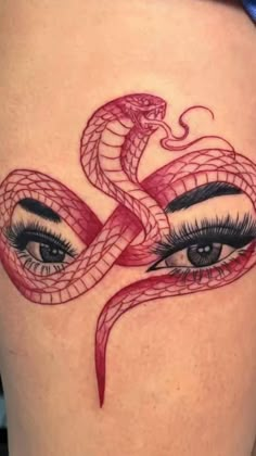 a woman's thigh with an eye and snake tattoo on it