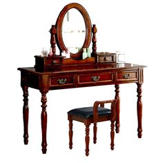 a wooden vanity table with a mirror and stool