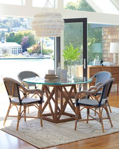 a dining room table with chairs and a rug on the floor in front of it