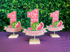 three watermelon slices are on top of each other in front of a purple table cloth