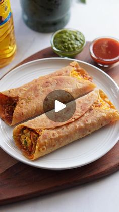 two burritos on a plate with salsa and ketchup