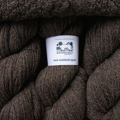 a skein of brown yarn with a white label on it that says new zealand sport