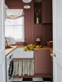 a kitchen with pink cabinets and white appliances in the corner, along with black and white checkered flooring