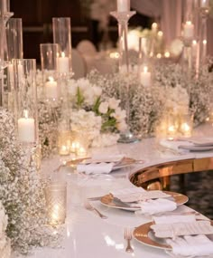 the table is set with white flowers and candles for an elegant dinner or reception party