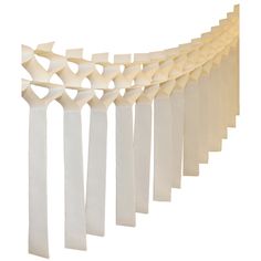 a white curtain is hanging on the side of a wall with long, wavy lines