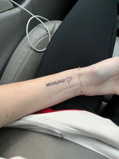 a woman's arm with a small heart tattoo on the left side of her wrist