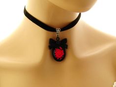 "Gothic choker Goth necklace Gothic jewelry Goth jewelry Gift for her Red Rose Black Cameo Necklace on Black Velvet choker Matching ring Gothic red rose cameo on a black background, set in a black acrylic bow tie topped frame. The cameo hangs from a velvet choker with a silver toned extender chain adjustable from 12.5 to 14.25 inches Cameo pendant - 2 inches Velvet choker necklace: 12.5-14.24 inches Arrives with a Marty White card in a lovely decorative bag and bubble wrap packaging. Facebook: h Adjustable Red Gothic Jewelry, Handmade Gothic Choker As Gift, Handmade Gothic Choker For Gift, Handmade Gothic Choker Gift, Adjustable Halloween Choker Gift, Gothic Adjustable Round Necklace, Gothic Red Jewelry Gift, Gothic Round Adjustable Necklace, Red Gothic Jewelry For Gift