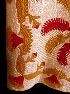 a close up of a quilt with red and yellow designs on it's edges