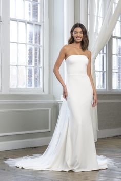 a woman in a white wedding dress posing for the camera