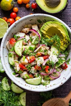 a white bowl filled with cucumber, red onion and avocado salad