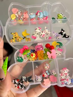 a person holding a plastic container filled with lots of small toy animals