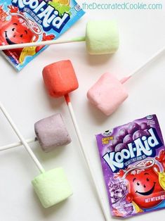 marshmallows and candy on a white table with two packets of kool aid