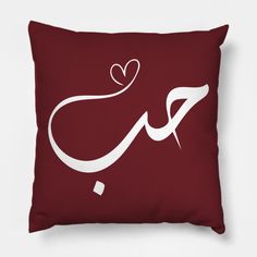 a pillow with the word love written in white on a maroon background, and a heart