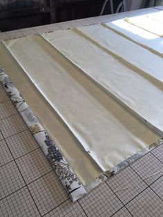 the fabric is laid out on the table to be used for making curtains and pillows