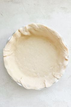 an uncooked pie crust on a white surface