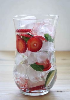 a glass filled with ice and strawberries