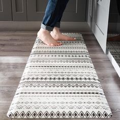 a person standing on top of a rug in a kitchen