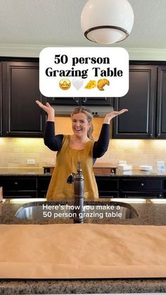 a woman standing in front of a kitchen counter holding up a sign that says 50 person grating table