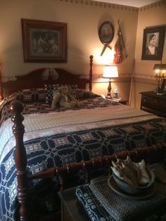 a bedroom with a bed, night stand and pictures on the wall