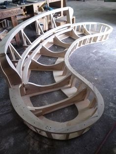 a wooden spiral staircase being constructed in a workshop