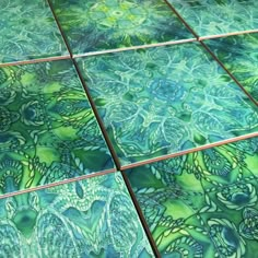 green and blue tiles are on the floor in an artistic pattern, which looks like leaves