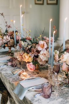 the table is set with flowers and candles for an elegant dinner party or wedding reception