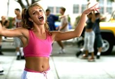 a woman in a pink top is holding her arms out and looking up at the sky