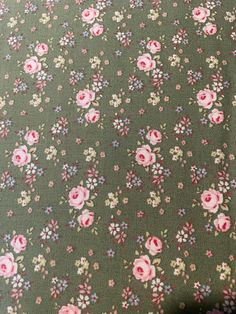 a green floral fabric with pink flowers on it